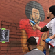 Artists paint a mural of former NFL quarterback Colin Kaepernick during “Kaeper Bowl” in Atlanta.